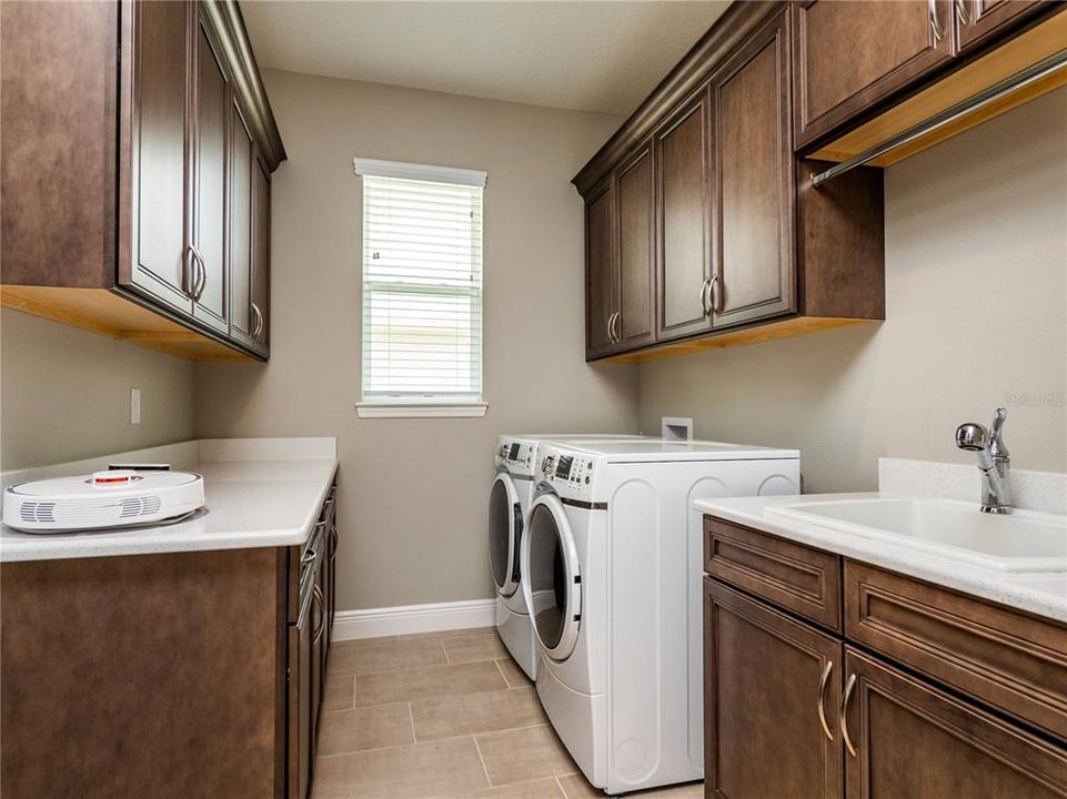 LAUNDRY ROOM WITH UTILITY SINK AND CABINET SPACE.