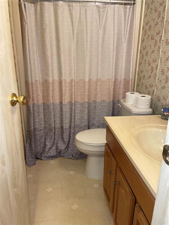 Full bathroom off living room with shower/tub combo
