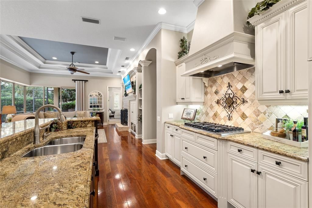 Viking Cooktop is enhanced by custom hood and tumbled travertine backsplash.   Very pretty.