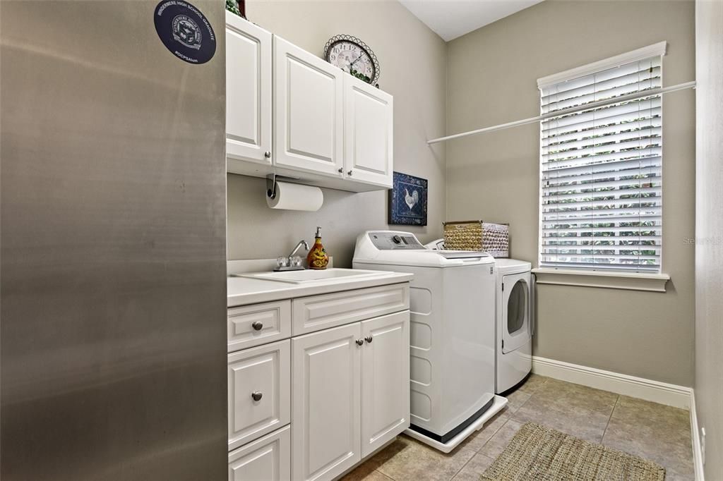 Large laundry room has sink and room for refrigerator