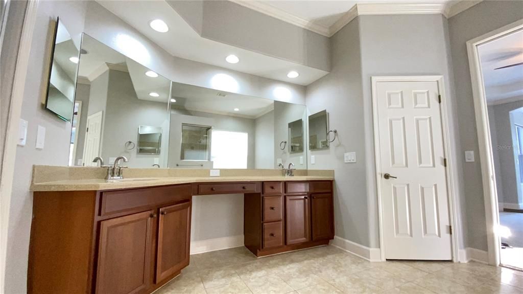 Master bath with dual sinks and vanity area
