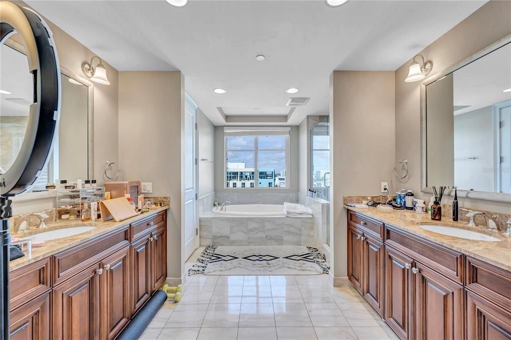 Bathroom, double sink each on one side, tub in middle, toilet separate and tub on other side!