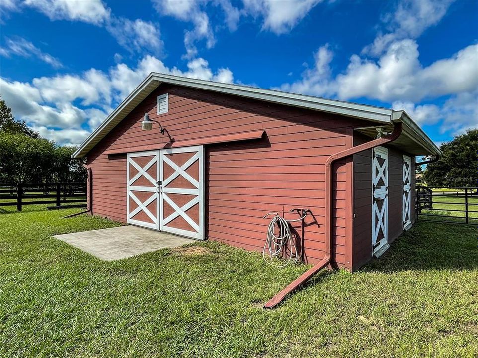 Barn has water, flood lights, attic exhaust fans,ceiling fan, two stalls, tack room and storage.
