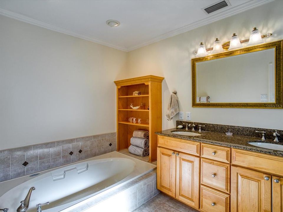 Master Bath (13'2" X 7'6")with Jetted Tub, and wood cabinets with Granite Counter Tops and Built in Shelving