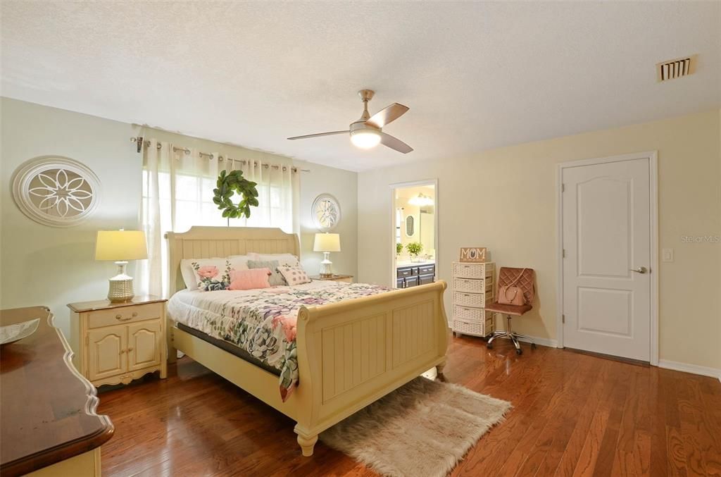Master bedroom features wood flooring, abundant light, walk-in closet with built-in shelving & renovated bathroom.