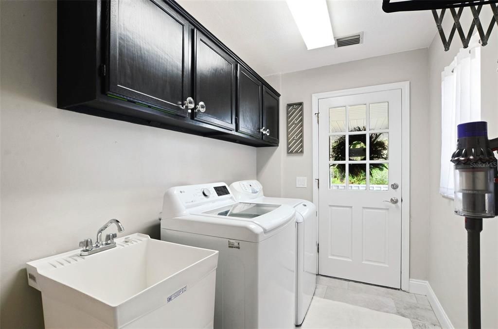 Laundry with cabinetry, clothing hanging rack, outdoor access & wash basin- W/D convey!
