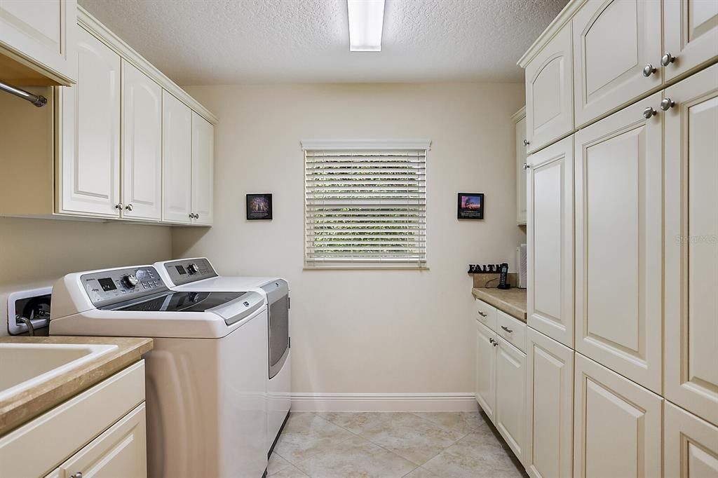 Inside laundry room with utility sink and extra cabinet space