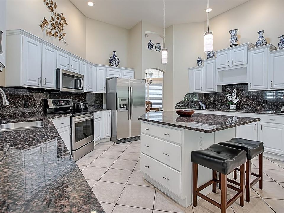 WHITE CABINETS WITH GRANITE COUNTER TOPS AND BACKSPLASH!  CONVENIENT BREAKFAST BAR AT THE END OF THE ISLAND!