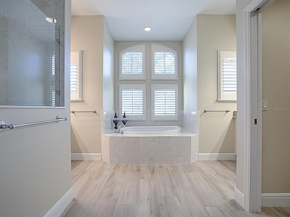 EN-SUITE MASTER BATH WITH A GARDEN TUB, PLANTATION SHUTTERS AND HIS AND HERS VANITIES!