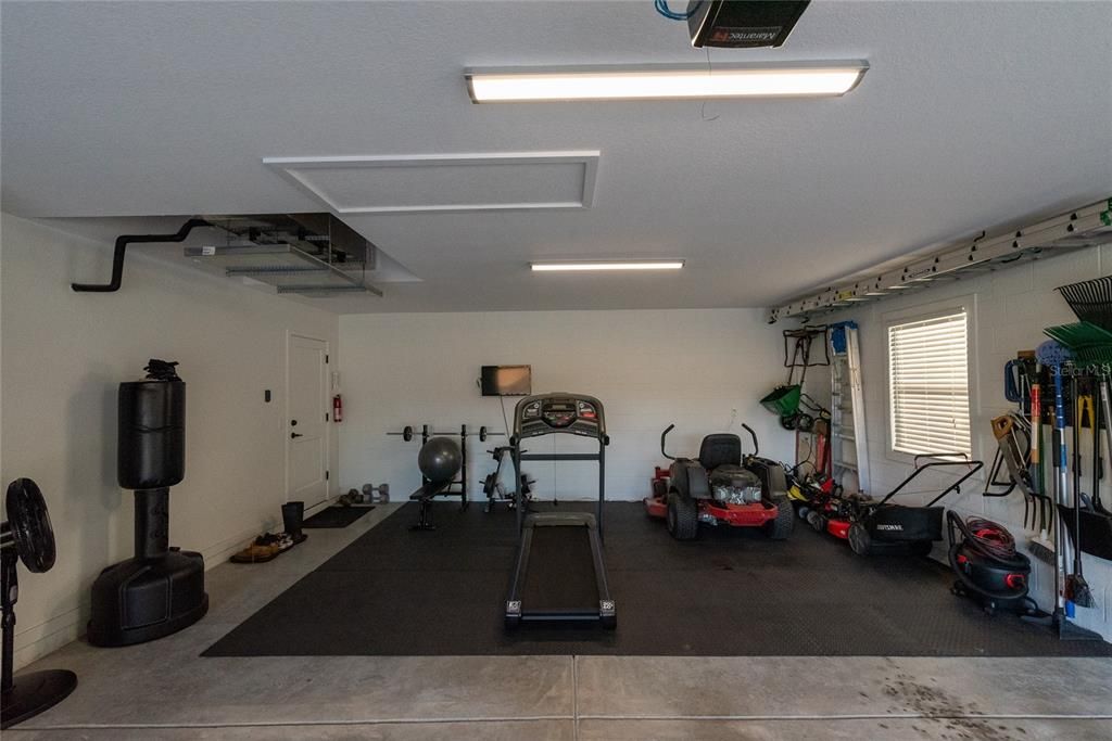 Extended portion of garage has room for lawn and workout equipment