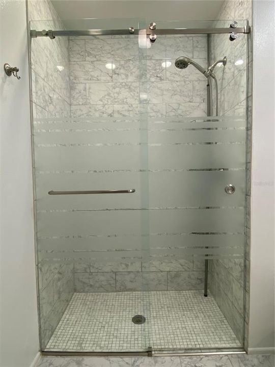 Walk in shower with frameless shower door and no curb