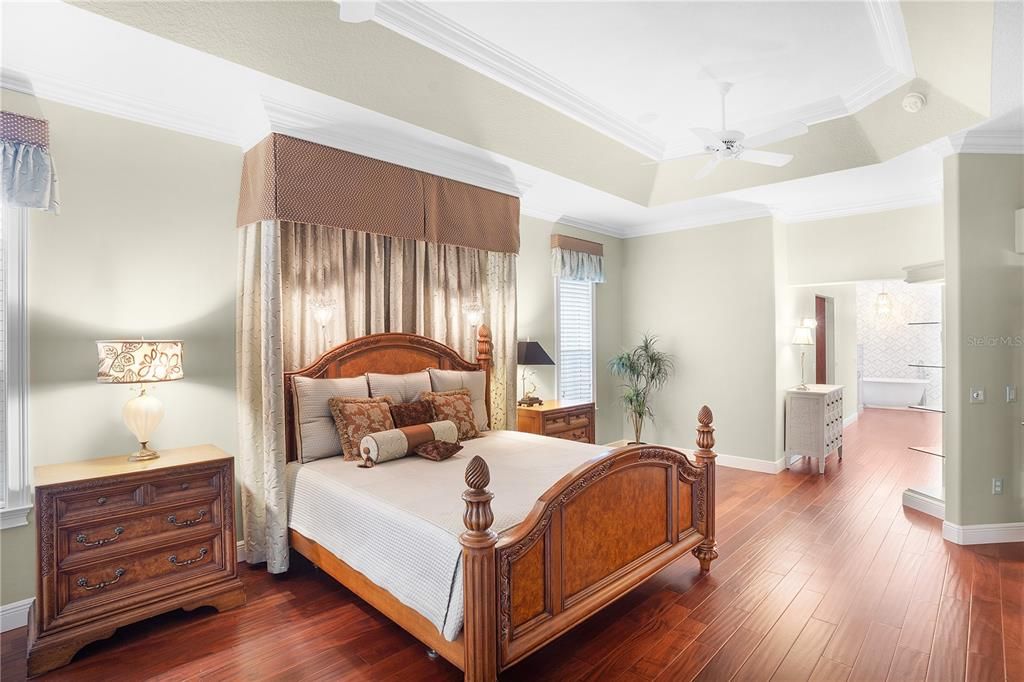 A very elegant master bedroom with tray ceiling