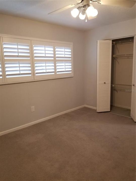 Bedroom 4 has Bahama shutters over the windows and a spacious closet.