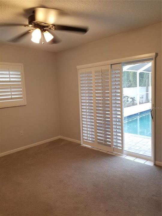 Bedroom 2 has glass sliding doors with sliding Bahama shutters to pool