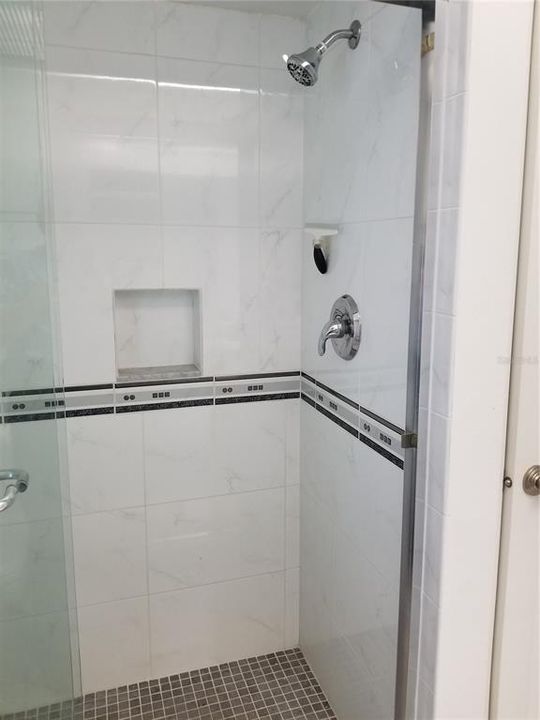 The Pool Bath with walk in Shower has marble floor tile