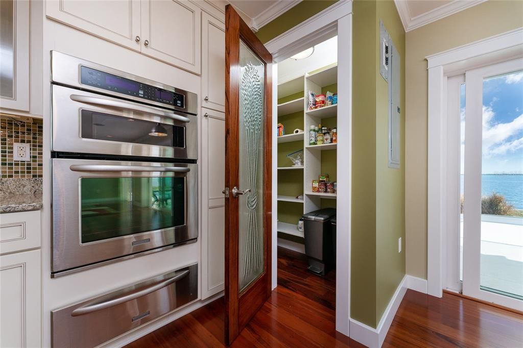 Beautiful walk in pantry with obscure glass door