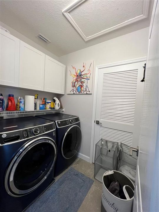 Beautifully appointed laundry room with new cabinets for plenty of storage.