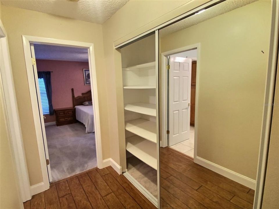 Spacious hall closet with built-in shelves & mirrored sliding doors