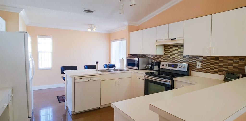 Kitchen with plenty of cabinets and counter space plus a breakfast bar.  Stainless Steel Stove which also includes a convention oven feature.  Sliding doors to access the fenced backyard.