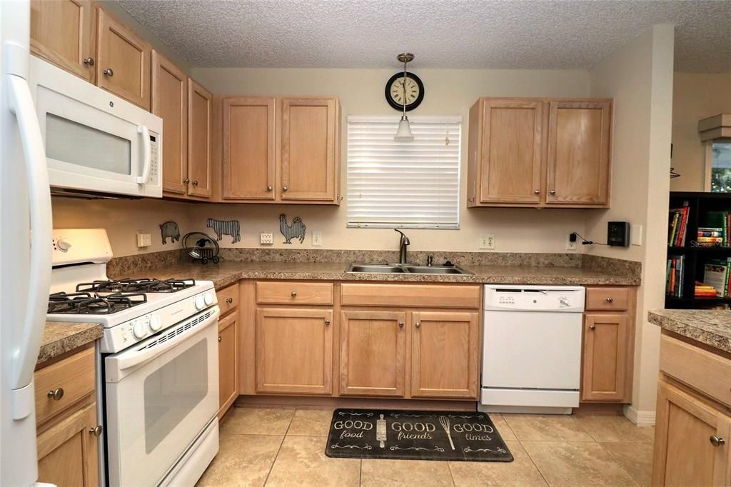 Lovely kitchen has tile flooring and a brand new diswasher, newer refrigerator and a gas range and microwave.  The solid wood cabinets have been refinished.