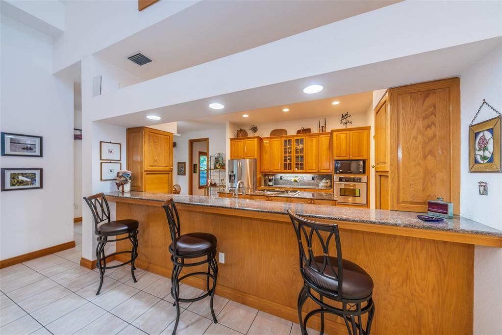 Granite breakfast bar is open to the kitchen and Gathering room