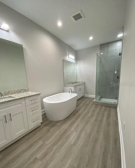 HUGE Owners bath with separate vanities, free standing tub and ceiling-to-floor tiled shower with bench seat.