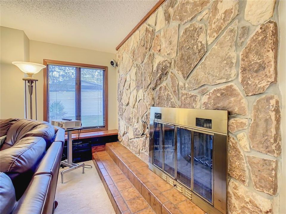 The warm glow of the wood burning fireplace can be enjoyed in both the living room and family room.