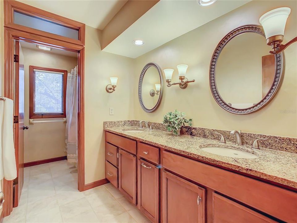 Guest bath has been remodeled with new cabinetry and double sinks.