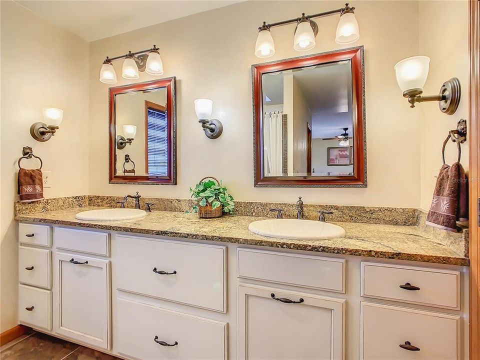 The en-suite bathroom has been remodeled with new cabinetry, granite countertop, double sinks and even has a built in clothes hamper.