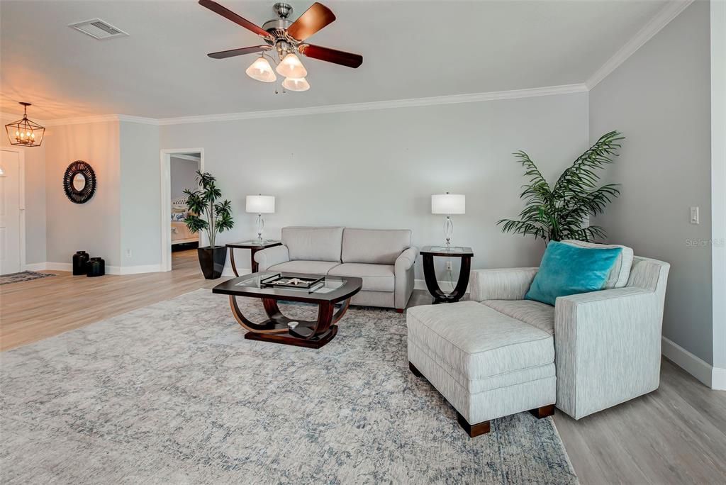 Another view of spacious room with guest bedroom in distance.  New flooring, light fixtures and fans make it so elegant.