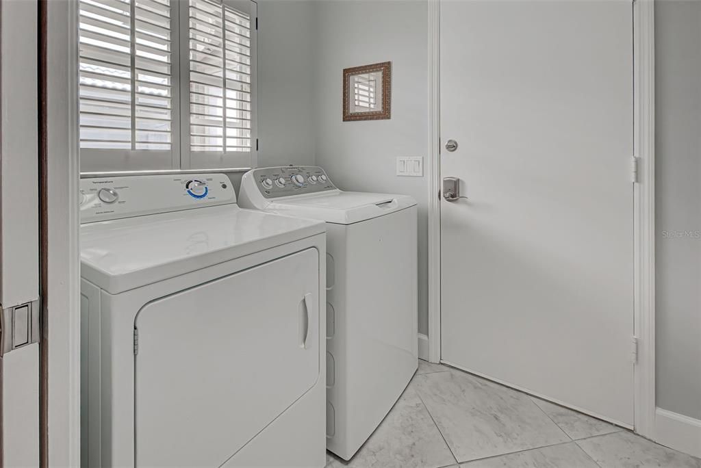 Interior laundry room conveniently leads from garage directly into kitchen.