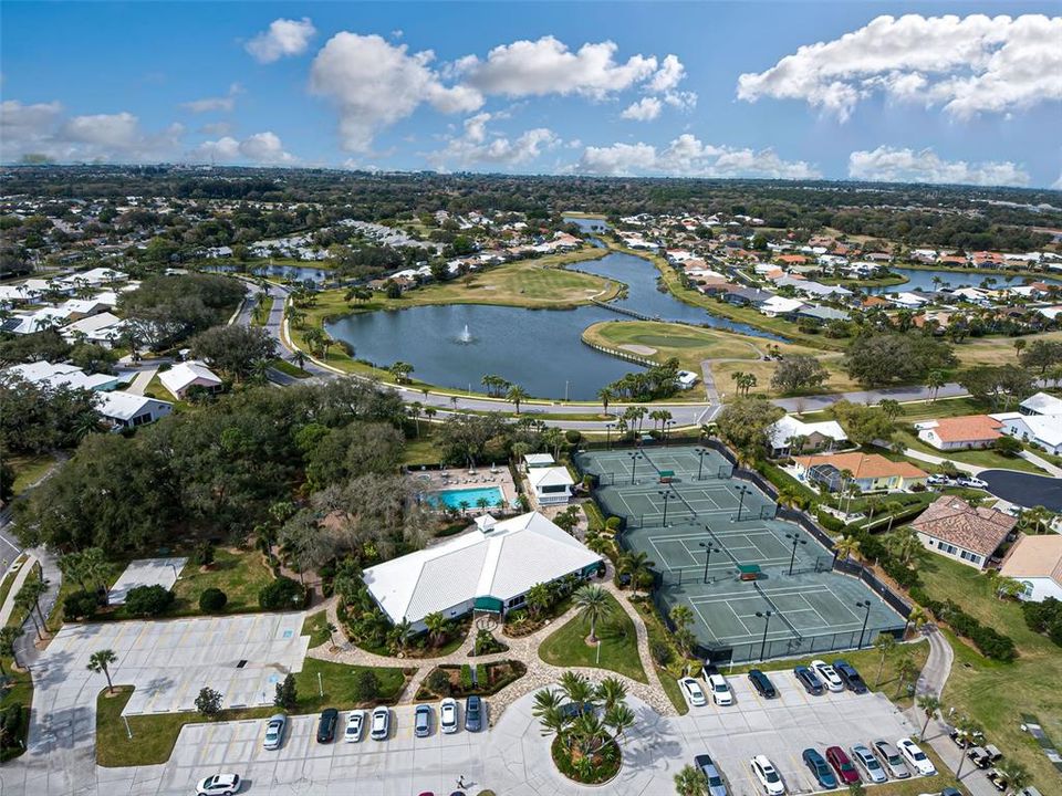 View of renovated clubhouse, community pool, tennis courts and lovely lake with fountain.
