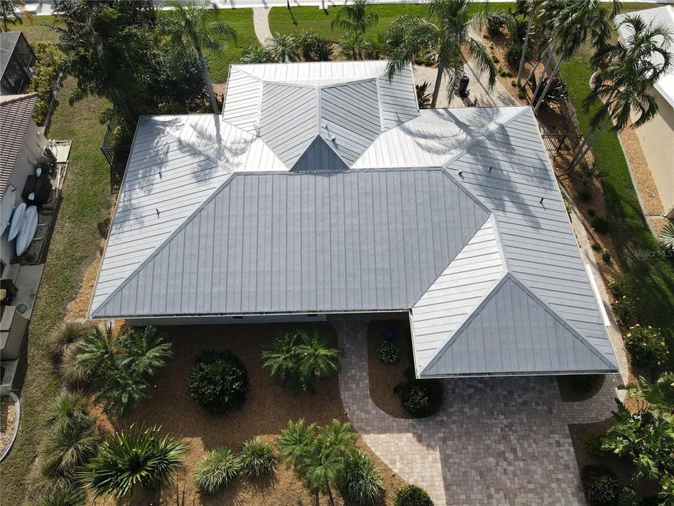 Metal roof with large brick paver driveway.
