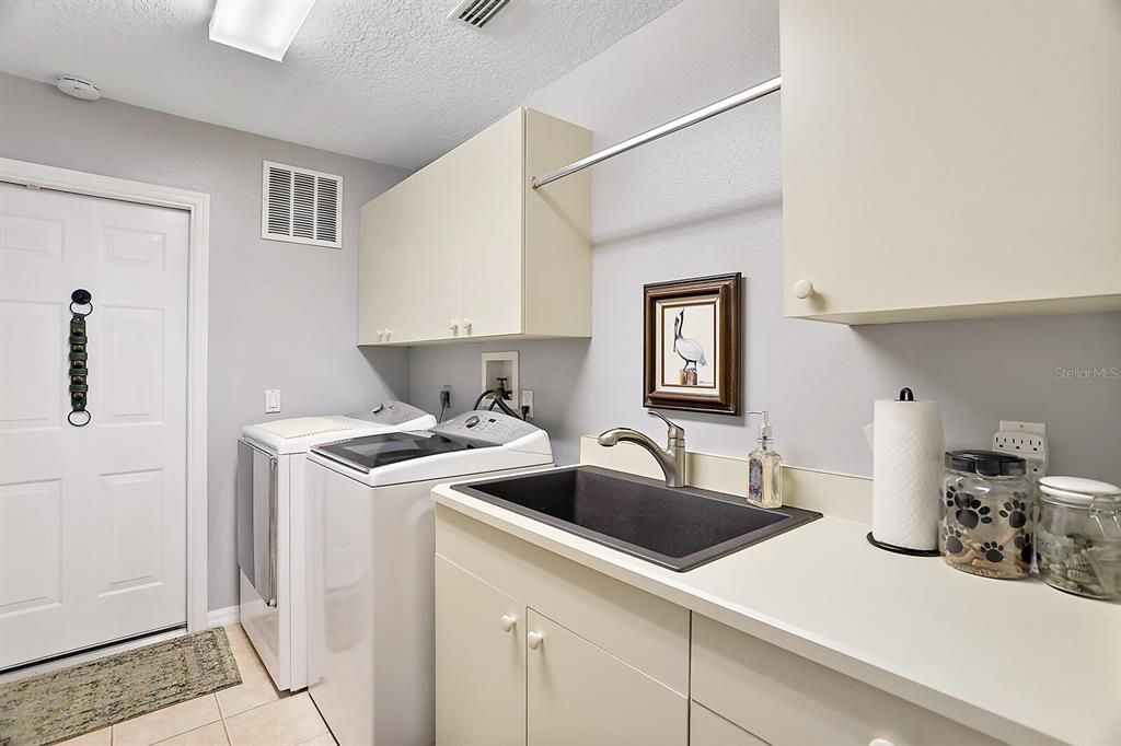 Downstairs Laundry Room with Sink and Storage.