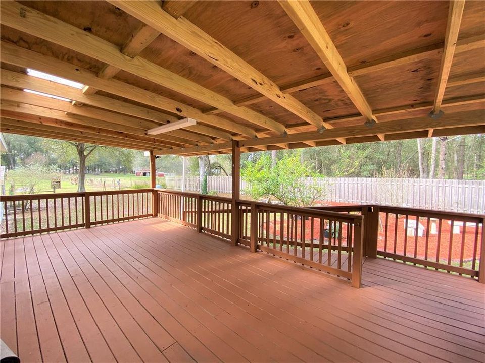 Large covered wooden deck/porch on back of home