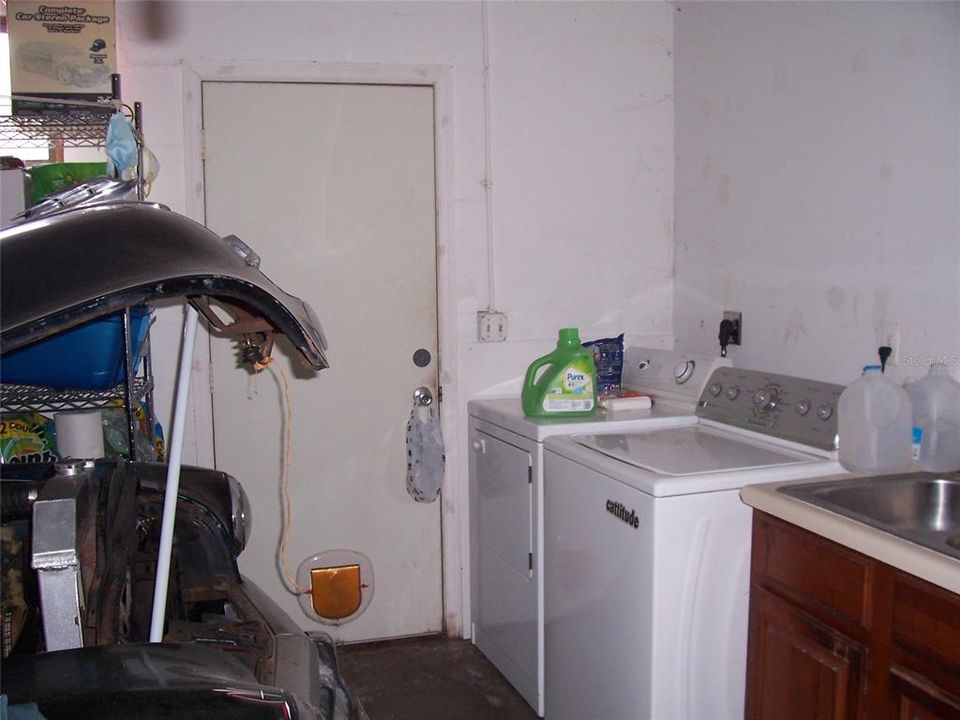 Laundry in Garage with outside door.