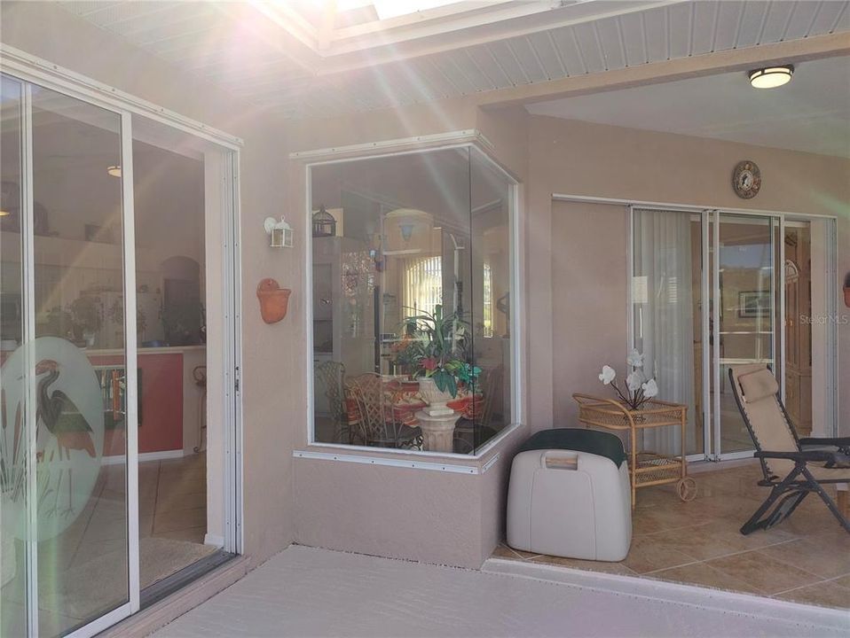 view from pool deck showing sliding door to family room, showing also the aquarium window from the dinette and pocket sliding door to the dining area