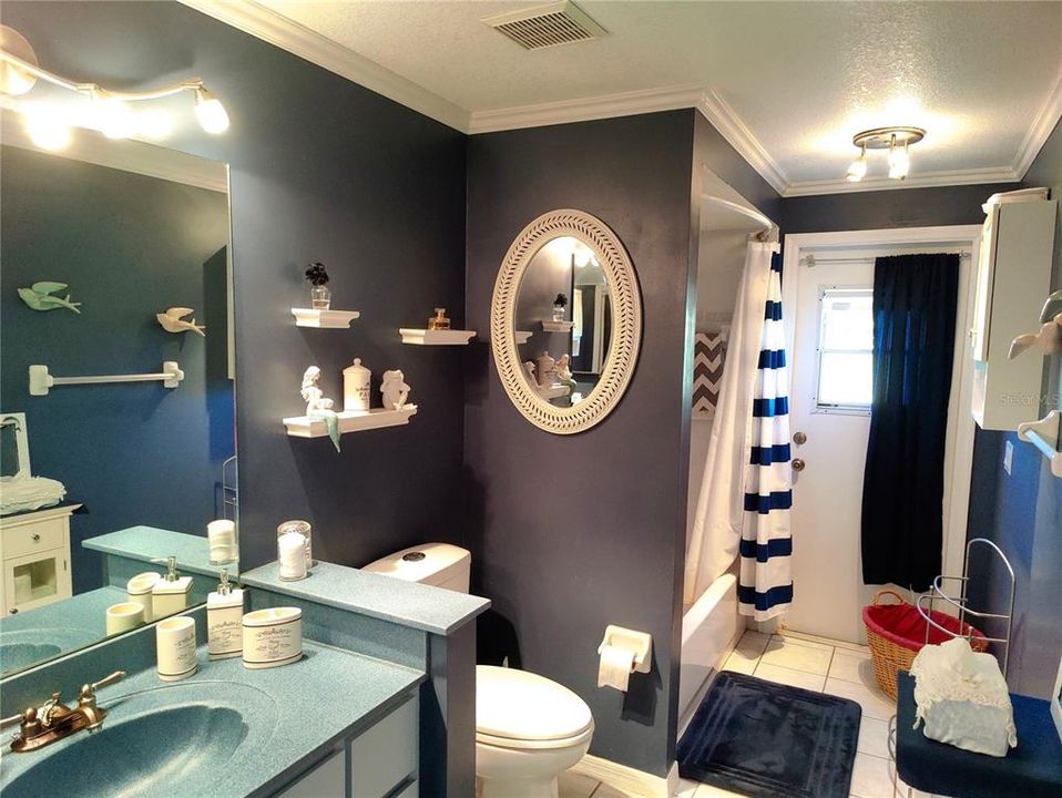 the guest bathroom has been also updated combo tub and shower, modern faucet and solid counter top with integrated shell sink, double flushing toilet elongated seat