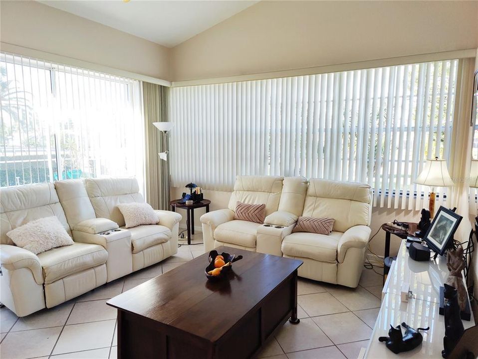 Family room has high cathedral ceiling wide windows and wide sliding doors, good quality blinds
