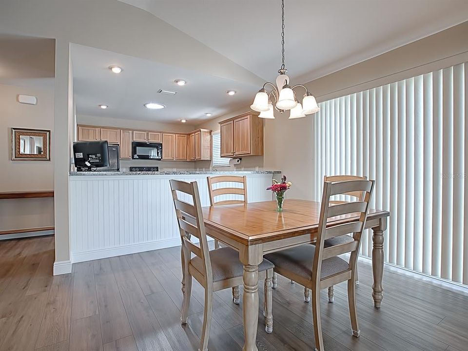 DINING AREA HAS CONVENIENT BREAKFAST BAR AND SLIDERS THAT LEAD TO THE SIDE YARD