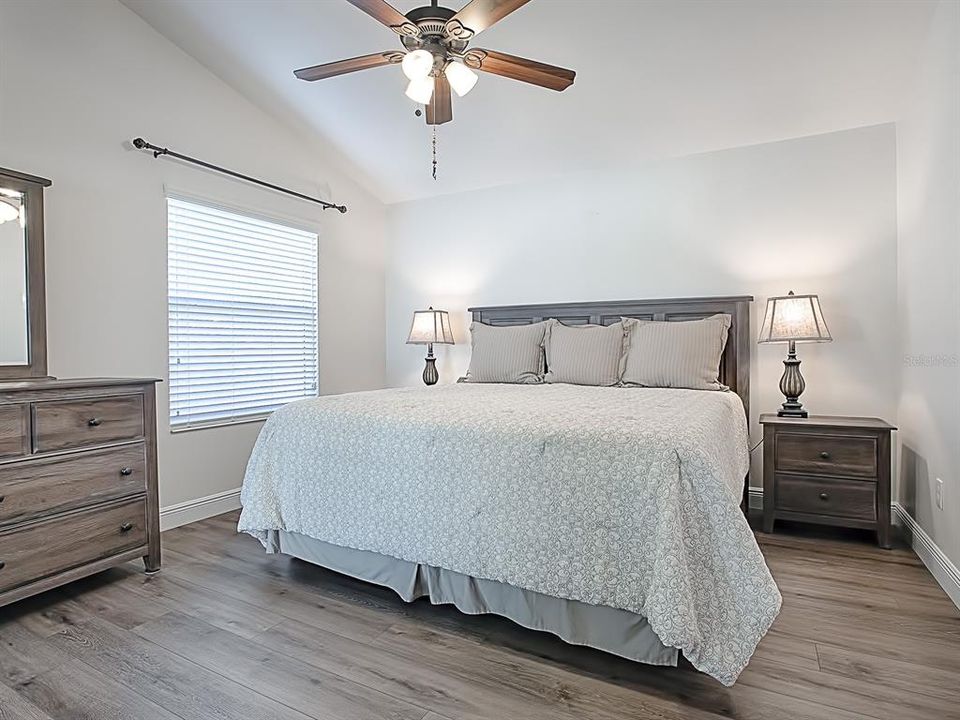 LIGHT AND AIRY MASTER BEDROOM WITH VAULTED CEILING AND LUXURY VINYL PLANK FLOORING