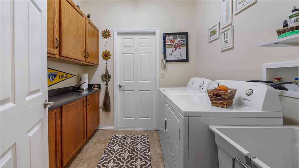 Downstairs laundry room with utility sink. Door leads to attached 2 car garage.