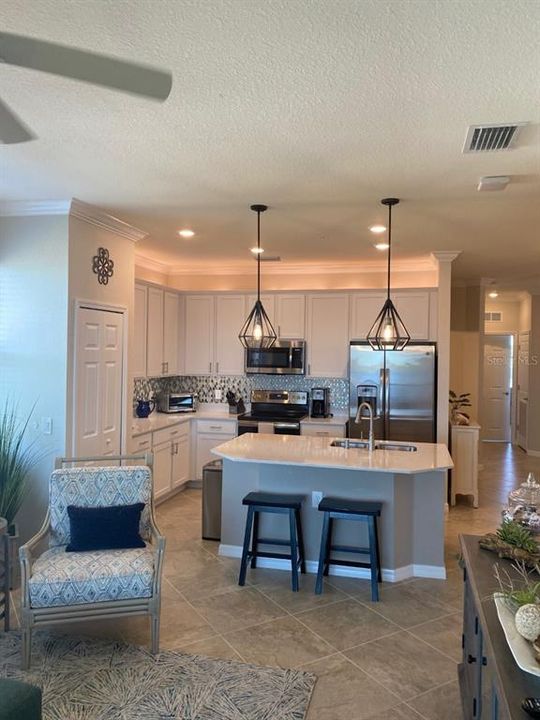 Kitchen island is quarty, nice lighting, backsplash added, pantry with built-ins.