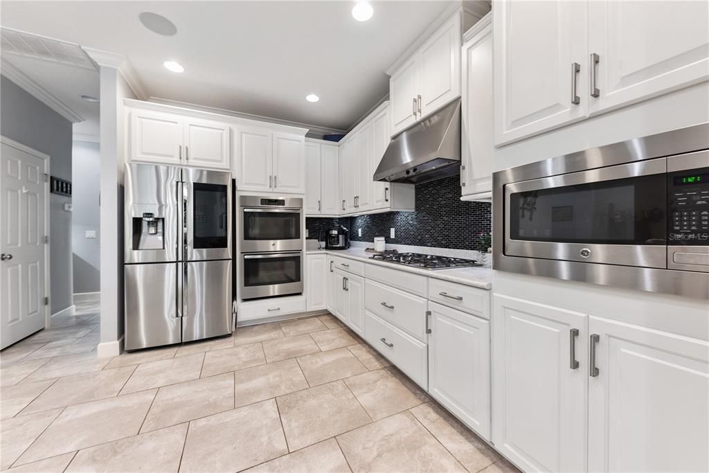 Quality stainless appliances enhance the kitchen with tile backsplash