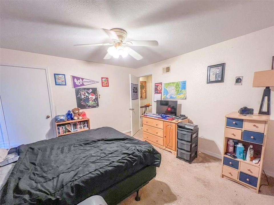 second bedroom with walk in closet, ceiling fan, carpeted, Eastern facing window