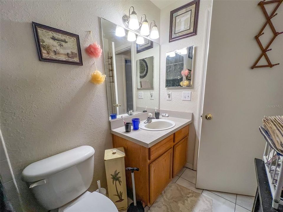 upstairs bathroom with tub/shower combo, handheld shower head with hose, under-sink storage cabinet