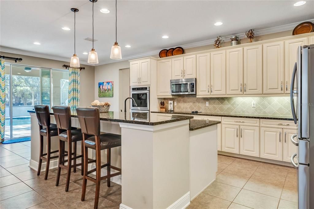The heart of this home is the light and bright open KITCHEN full of UPGRADES and boasting SOLID WOOD CABINETS, STONE COUNTERS, STAINLESS STEEL APPLIANCES including a DOUBLE OVEN, a butler's pantry complete with a WINE STORAGE closet and a massive ISLAND with BREAKFAST SEATING perfecting for a casual gathering!