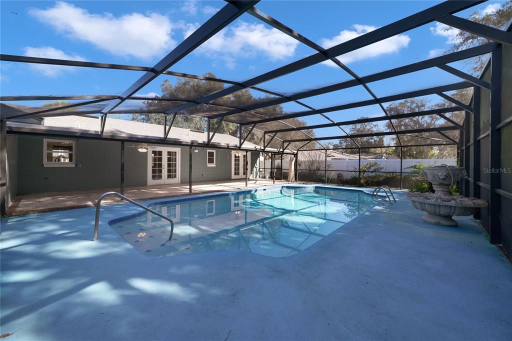 The expansive COVERED PATIO is a perfect place to relax in the shade poolside with family and friends, the POOL has recently been re-surfaced, is completely SCREENED IN and ready for Summer!