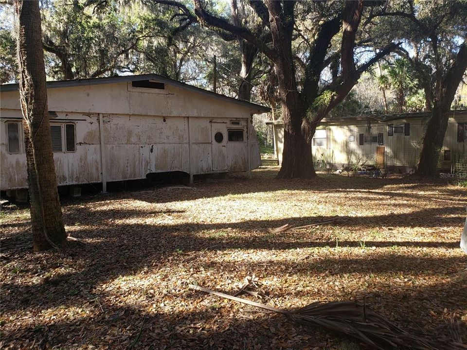 Back yard with storage shed and mobile home in background