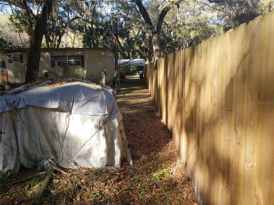 Back yard showing wood fence between neighbor